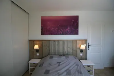 a bedroom with a bed with two tables and a painting on the wall at 225 Chemin des Joncs in Saint-Pierre-de-Vassols