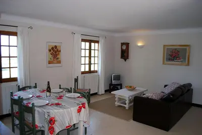 a living room with a table and a couch and a table and chairs at Amandier in Mazan