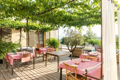 an outdoor patio with tables and chairs at Une Sieste en Luberon in Bonnieux