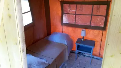 a small bedroom with a bed and a small table at Acacia in Mazan