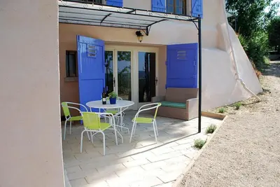 a patio with a table and chairs in front of a house at Olivier in Mazan