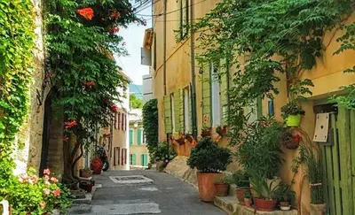 an alley with potted plants on the side of a building at La Bastide des Vasses l'Atelier in Cucuron