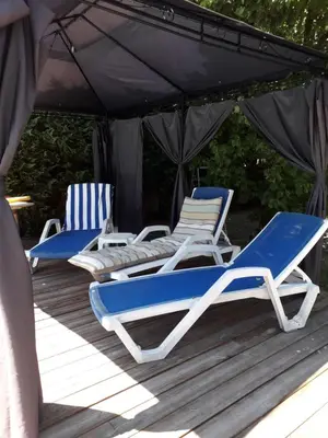 two lounge chairs and an umbrella on a deck at Brig'Gîte in LʼIsle-sur-la-Sorgue