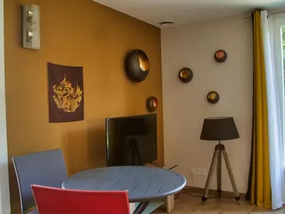 a dining room with a blue table and a tv at Brig'Gîte in LʼIsle-sur-la-Sorgue