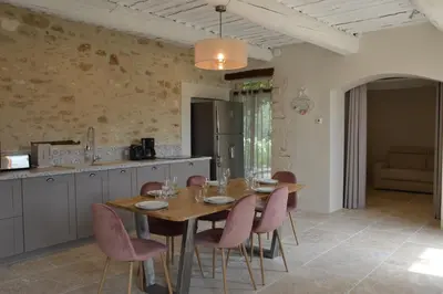 a kitchen and dining room with a wooden table and chairs at Les Gîtes Du Clos D'Olea in Oppède