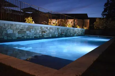 a swimming pool lit up at night at Le Clos D'Olea in Oppède