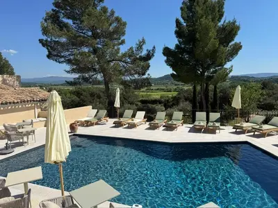 a pool with chairs and umbrellas in a villa at Le Mas de Garrigon - Boutique Hôtel & Spa in Roussillon