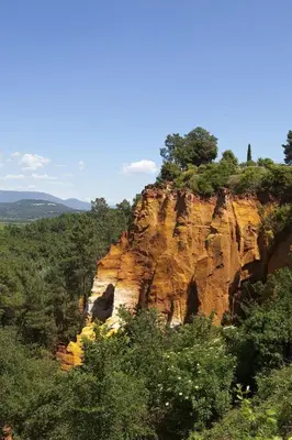 a rocky mountain with trees on top of it at Le Mas de Garrigon - Boutique Hôtel & Spa in Roussillon
