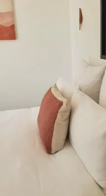 a pillow sitting on top of a white bed at Le Mas de Garrigon - Boutique Hôtel & Spa in Roussillon