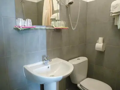 a bathroom with a white sink and a toilet at Hotel Régina in Salon-de-Provence