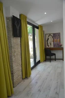 a living room with yellow curtains and a wooden floor at Domaine Shambala - gîte en Provence avec une Grande Piscine in Velaux