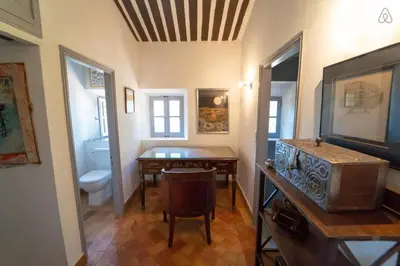 a room with a table and a bathroom with a toilet at Stunning panoramic views and heated pool in Roussillon in Roussillon