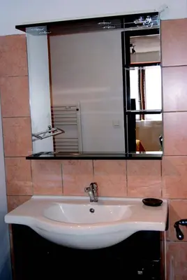 a white sink in a bathroom with a mirror at La goutte d'or in Roussillon