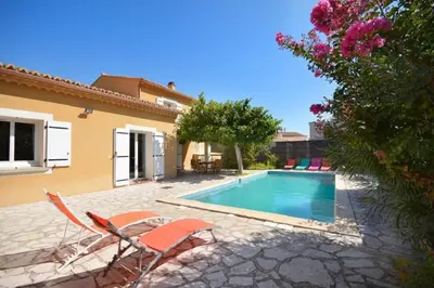 a villa with a swimming pool in front of a house at Villa charmante à Saint-Didier avec piscine privée in Saint-Didier