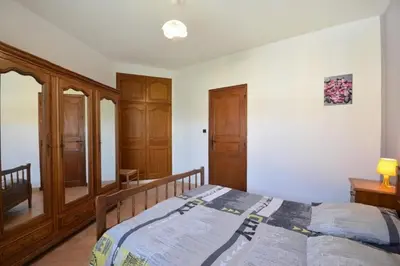 a bedroom with a bed and wooden cabinets at Villa charmante à Saint-Didier avec piscine privée in Saint-Didier
