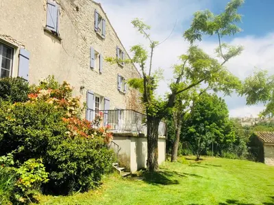 an apartment building with a balcony and a yard at Gîte La Bastide de La Loge au pied du Mont Ventoux in Sault-de-Vaucluse