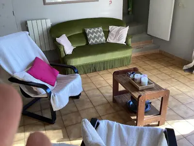 a living room with a green couch and a table at 196 rue des moulins in Vachères