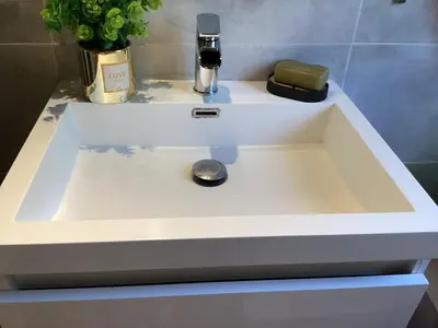 a white sink in a bathroom with a flower at 196 rue des moulins in Vachères