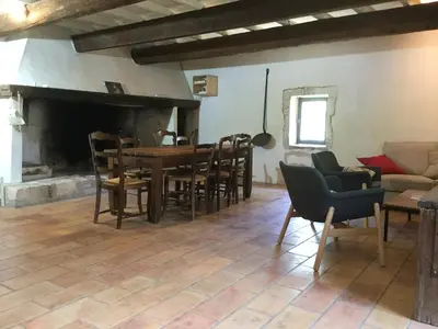 a living room with a table and chairs and a fireplace at typical provencal farm in an exceptional natural site, the alpilles park - 8 people. in Maussane-les-Alpilles