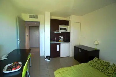 a room with a kitchen and a living room at KOSY Appart'Hôtels - Campus Del Sol Esplanade in Montfavet