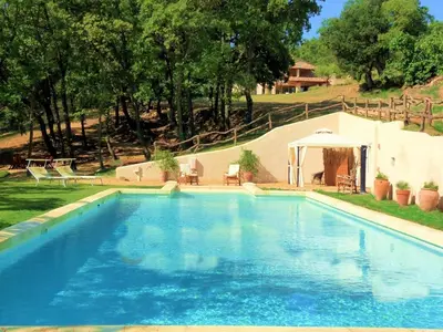 a large swimming pool in a yard with a tent at Le Mas Sérénité in Ansouis