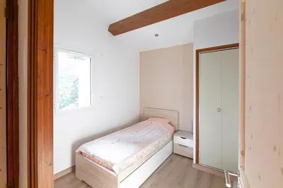 a small bedroom with a bed and a window at Le Clos Zinou in Lambesc