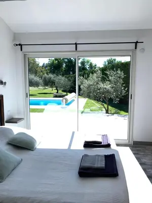 a bedroom with a large bed and a large window at Le Mazet Des Joncs en Provence in Saint-Pierre-de-Vassols