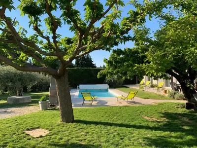 a pool in a yard with two chairs and a tree at Le Mazet Des Joncs en Provence in Saint-Pierre-de-Vassols