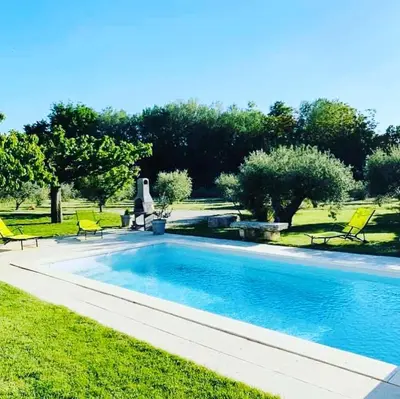 a swimming pool with yellow chairs next to a yard at Le Mazet Des Joncs en Provence in Saint-Pierre-de-Vassols