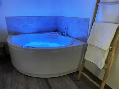 a blue tiled bathroom with a tub and a towel at Mas la Chêneraie Lourmarin - Au calme, à 10 mn du centre ville à pied in Lourmarin