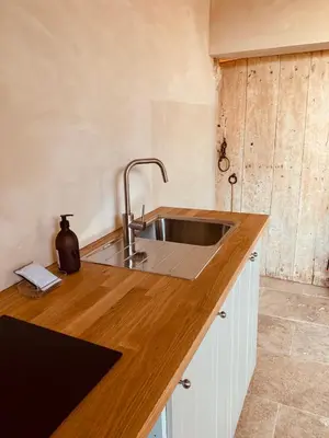 a kitchen with a sink and a wooden counter top at Le Vieux Portail in Saint-Saturnin-les-Apt