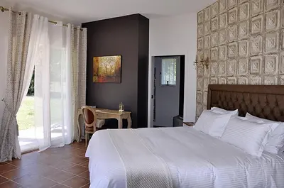 a bedroom with a white bed and a window at Le Jardin des Amandiers in Châteaurenard
