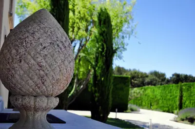 a large stone vase sitting in front of a building at Le Jardin des Amandiers in Châteaurenard