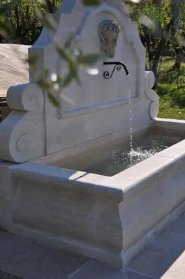 a stone fountain with water coming out of it at Le Jardin des Amandiers in Châteaurenard