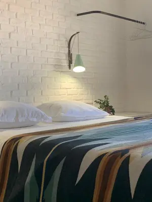 a bedroom with a bed with a white brick wall at Le 40 in LʼIsle-sur-la-Sorgue