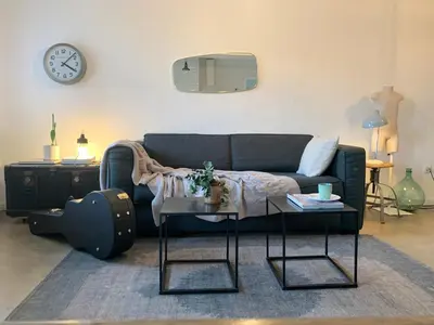 a living room with a couch and a table at Le 40 in LʼIsle-sur-la-Sorgue