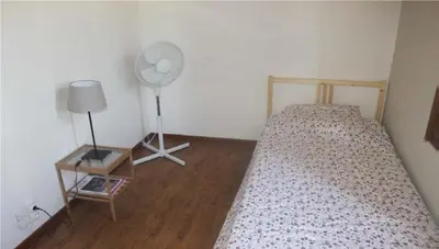 a bedroom with a bed with a fan and a table at Vakantiehuis Mazan - Le Haut Colombier in Mazan