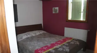 a bedroom with a bed and a mirror and purple walls at Vakantiehuis Mazan - Le Haut Colombier in Mazan