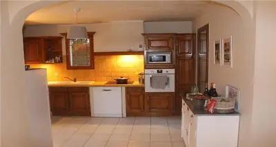 a kitchen with wooden cabinets and white appliances at Vakantiehuis Mazan - Le Haut Colombier in Mazan
