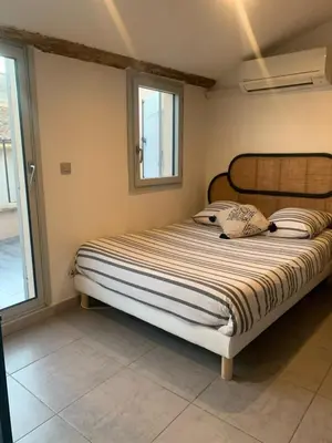 a large bed in a bedroom with a window at Studio avec Terrasse in Aix-en-Provence