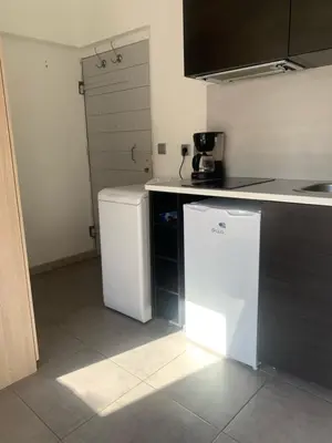 a kitchen with a white refrigerator and a counter at Studio avec Terrasse in Aix-en-Provence