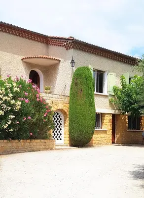 a house with a large bush in front of it at les oliviers in Carpentras