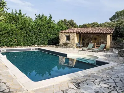 a swimming pool in a backyard with a stone house at Villa La Chênaie by Interhome in Saumane-de-Vaucluse