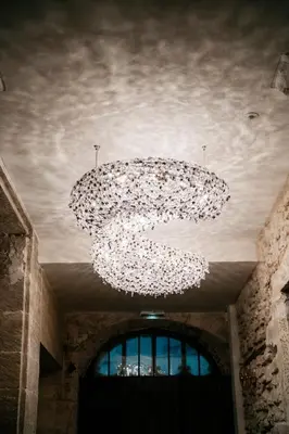 a large chandelier hanging from the ceiling in a building at Le Clos Violette et Le 11 D'Aglaé - Appart' Hôtel de Charme Design de Luxe in LʼIsle-sur-la-Sorgue