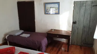 a room with two beds and a desk and a window at la bastide de l'adrech in Manosque