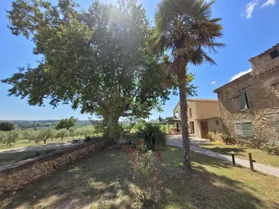 a house with a palm tree and a building at la bastide de l'adrech in Manosque