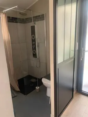 a bathroom with a shower and a toilet with a speaker at studio avec exterieur in Eyragues