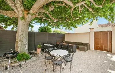 a patio with a table and chairs under a tree at Amazing Home In Vedène in Vedène