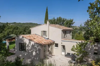 an external view of a white house with a steeple at Les Amandiers in Bonnieux