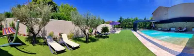 a yard with a swimming pool with lounge chairs next to at Au Murmure de la Sorgue in LʼIsle-sur-la-Sorgue